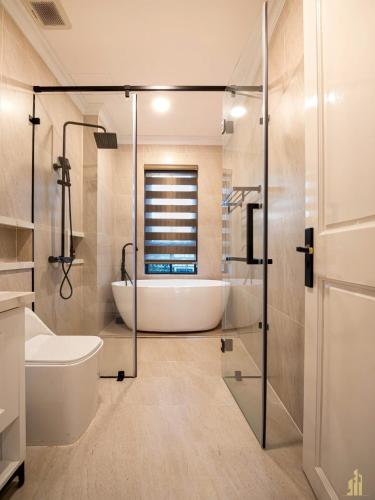 a bathroom with a tub and a toilet and a sink at Phan Thiết Nova World Malibu 2 Villa in Phan Thiet
