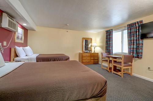 a hotel room with two beds and a desk at Classic Inn in Saco