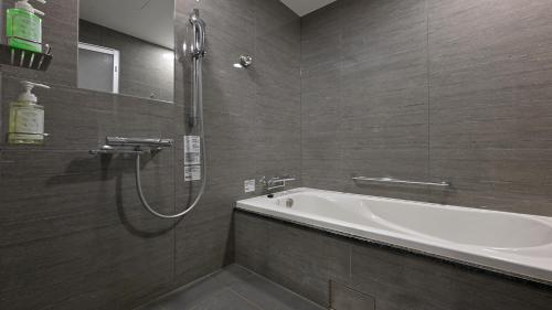 a bathroom with a bath tub and a shower at QUINTESSA HOTEL The Collection Osaka Bay in Osaka