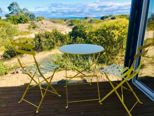 a table and two chairs sitting on a porch at Driftwood Cottage in Dolphin Sands