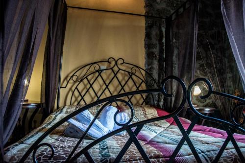 a bed with a black iron bed frame with a blanket at Theasis suites-Ορεινή Φιλοξενία in Kato Trikala Korinthias