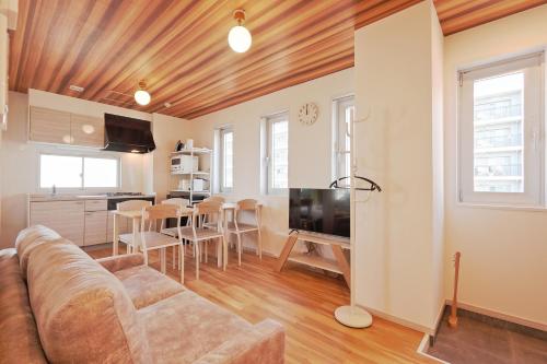 a living room with a couch and a kitchen at V Close to Kojiya sta 15 min to Haneda Roof top B in Tokyo