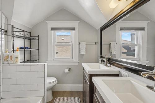 a bathroom with a sink and a toilet and a window at 5-Bedroom Victorian Home Private Yard Sleeps 10 in Denver