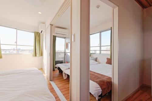 a bedroom with two beds and a mirror at V Close to Kojiya sta 15 min to Haneda Roof top B in Tokyo