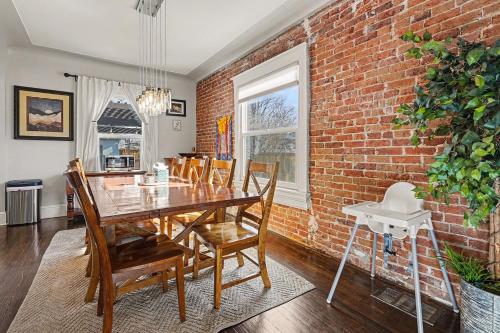 a dining room with a table and a brick wall at 5-Bedroom Victorian Home Private Yard Sleeps 10 in Denver