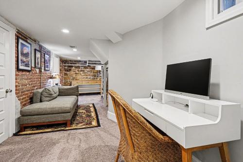a living room with a white desk with a television at 5-Bedroom Victorian Home Private Yard Sleeps 10 in Denver