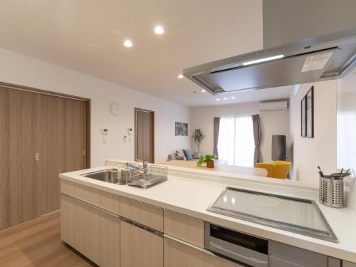 a kitchen with a sink and a counter top at 新築貸し切り宿 Karatsu House A in Karatsu