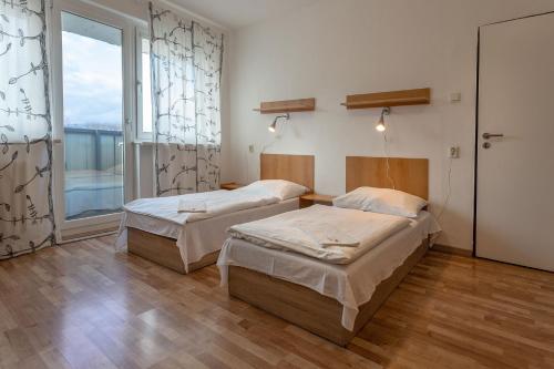 a room with two beds and a large window at Hostel Turist in Zvolen