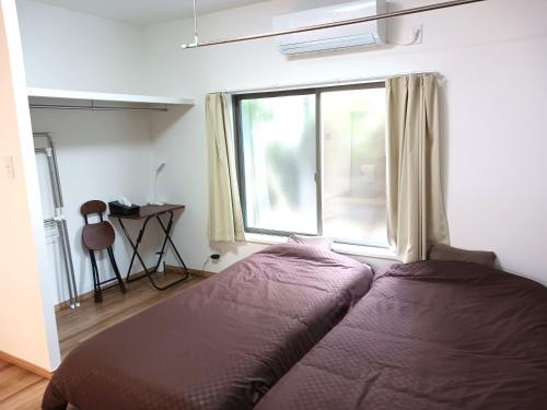 a bedroom with a bed in front of a window at 別館JOUNi in Niijimamura