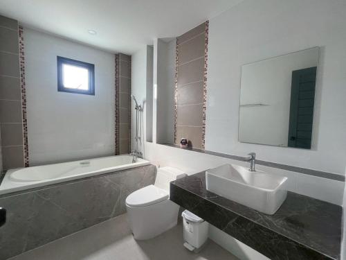 a bathroom with a sink and a toilet and a tub at Pool villa Cream Darin in Ban Hua Phrong