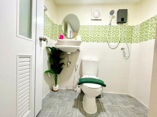 a bathroom with a toilet and a sink and a shower at Tiny Secret in Ban Tai