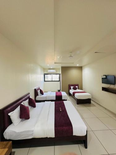 a large room with two beds in it at Atland Residency in Calicut