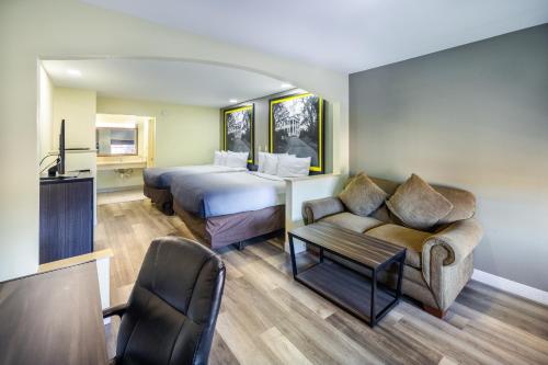 a hotel room with a bed and a couch at Super 8 by Wyndham Jackson MS Near the Fairgrounds in Jackson