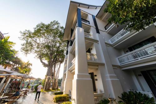 a man walking down a sidewalk in front of a building at Buri Sriping Riverside Resort & Spa in Chiang Mai