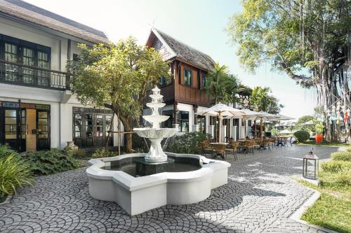 a fountain in a courtyard in front of a building at Buri Sriping Riverside Resort & Spa in Chiang Mai