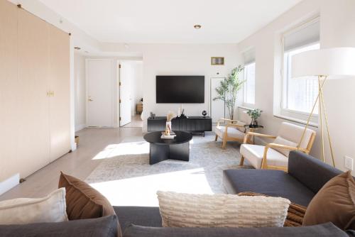 a living room with a couch and a tv at RARE Luxurious Apartment 1 Block From Time Square in New York