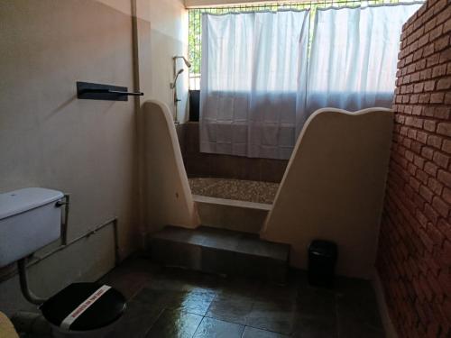 a small bathroom with a shower and a toilet at Ambalama Leisure Lounge in Hanwella