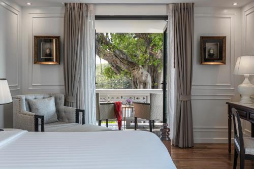 a bedroom with a bed and a large window at Buri Sriping Riverside Resort & Spa in Chiang Mai
