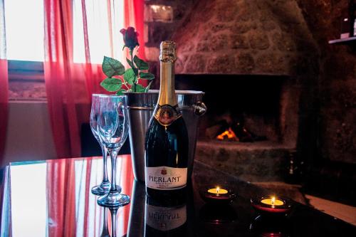 a bottle of wine and a glass on a table at Theasis suites-Ορεινή Φιλοξενία in Kato Trikala Korinthias