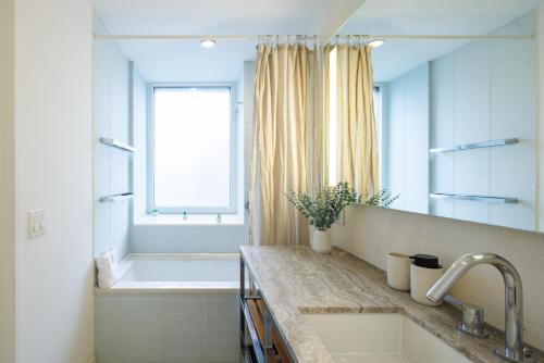 a bathroom with a tub and a sink and a bath tub at Stylish NYC Haven Steps to Broadway & Dining in New York
