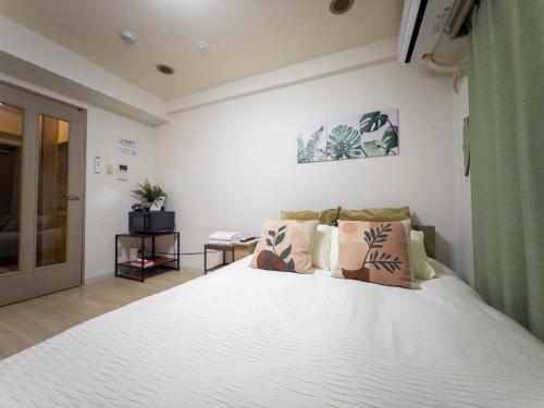a bedroom with a large white bed with pillows at Ichigaya Stay & Wi-Fi 1 in Tokyo