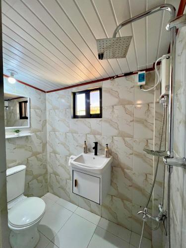 ein Badezimmer mit Toilette, Waschbecken und Dusche in der Unterkunft L Casa in Coron