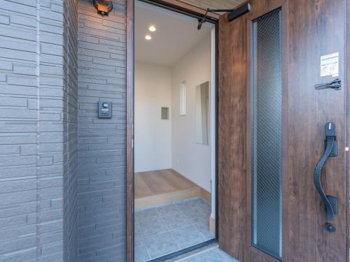 a glass shower door in a bathroom with a shower stall at 新築貸し切り宿 Karatsu House B in Karatsu