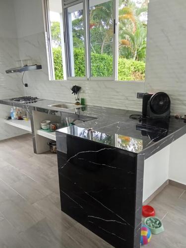 a kitchen with a black counter top in a room at Finca Villeta in Villeta