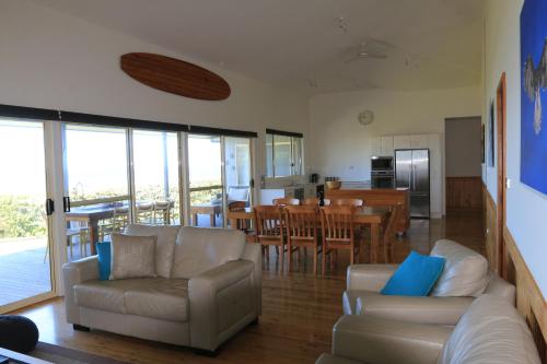 a living room with a couch and a dining room at Bunkys By The Sea Holiday House in Berrara