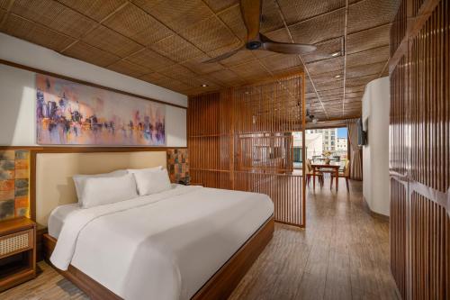 a bedroom with a large bed and a dining room at LUK Inn Hotel - An Thuong, Da Nang in Danang