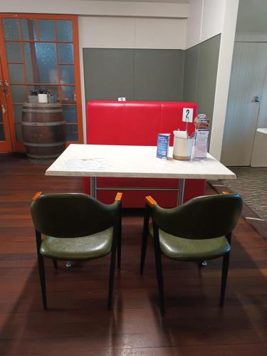 a table and two chairs in a waiting room at GRAND CENTRAL HOTEL PROSERPINE in Proserpine