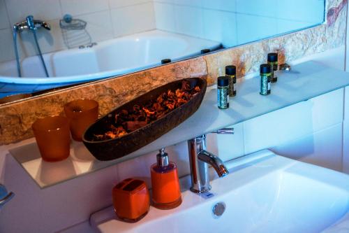 a bathroom with a sink and a bath tub at Theasis suites-Ορεινή Φιλοξενία in Kato Trikala Korinthias