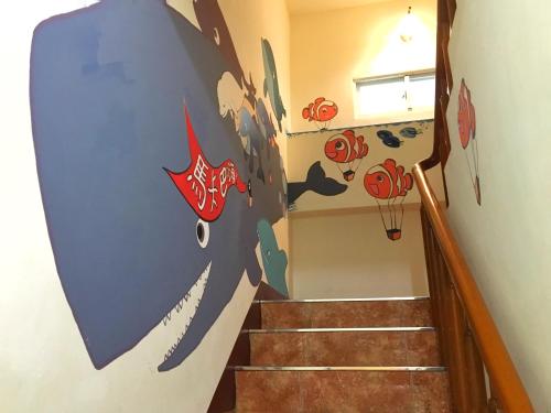a staircase with a painting of a shark on the wall at Camellia B&B in Taitung City