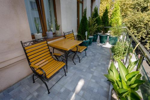 a wooden table and chairs on a patio with plants at Mais Guest House in Tbilisi City