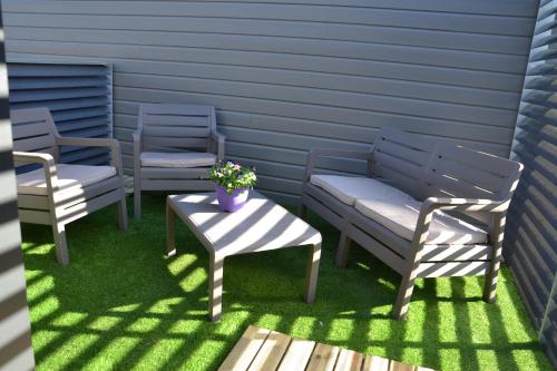 a patio with two chairs and a table and a bench at Appartement Alouette France in Pessac