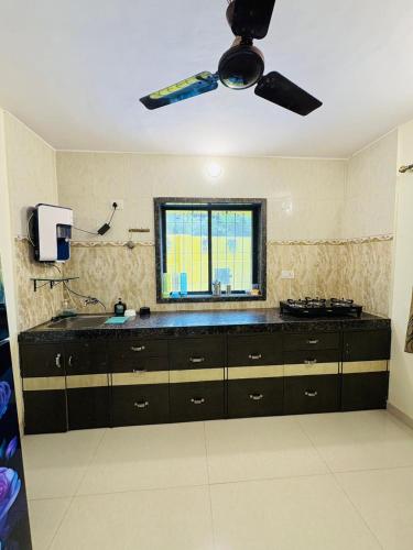 a kitchen with a sink and a ceiling fan at Between The Raindrops in Lonavala