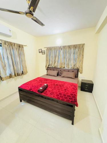a bedroom with a large bed with a red blanket at Between The Raindrops in Lonavala
