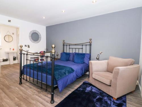 a bedroom with a bed and a chair at Chalet 1 in Ganton