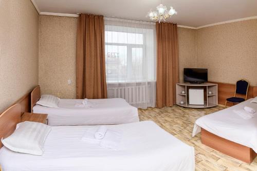 a hotel room with two beds and a television at Гостиница Караганда in Karagandy
