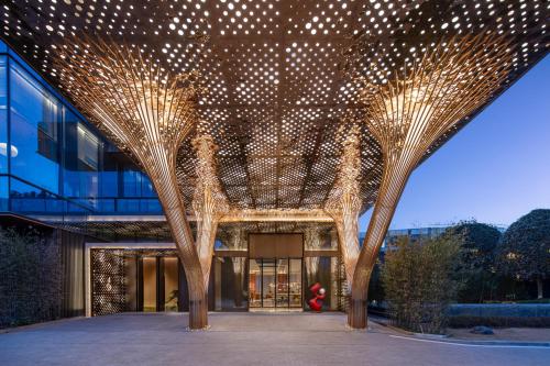 a building with trees with lights on it at Hotel Indigo Xi'an High-tech Zone by IHG in Xi'an