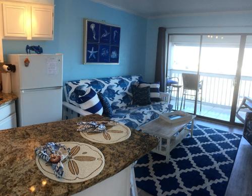 a kitchen and living room with a couch and a counter at Casa Del Mar Beach View in Galveston