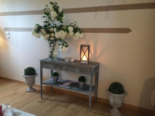 a table with a vase of flowers in a room at Le Grand Gîte in Dorengt