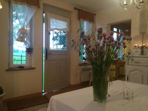 a vase filled with flowers sitting on a table at Le Grand Gîte in Dorengt