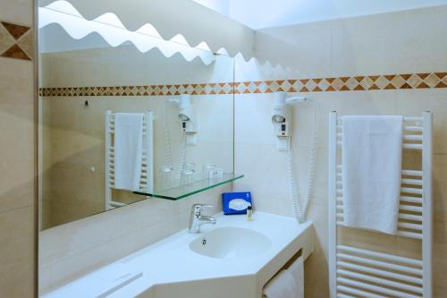 Hotel Helgoland في هامبورغ: حمام أبيض مع حوض ومرآة