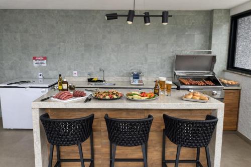 a kitchen with plates of food on a counter at PISCINA, 2qts, 2 banh, varanda c churrasqueira, estacionamento, elevador, portaria in São Lourenço