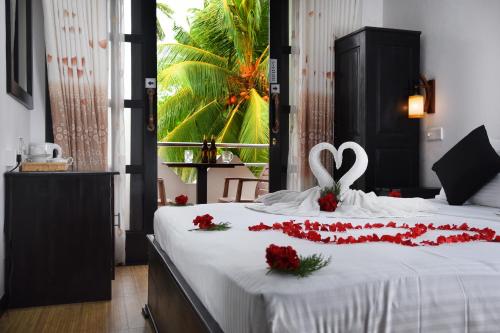 L&D Lodge في هيكادوا: غرفة نوم عليها سرير وديكور قلبي