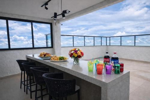 a bar with plates of food and drinks on a balcony at PISCINA, 2qts, 2 banh, varanda c churrasqueira, estacionamento, elevador, portaria in São Lourenço
