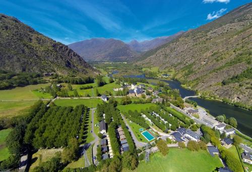 eine Luftansicht eines Resorts mit Fluss und Bergen in der Unterkunft Bungalows Nou Camping in La Guingueta d'Àneu