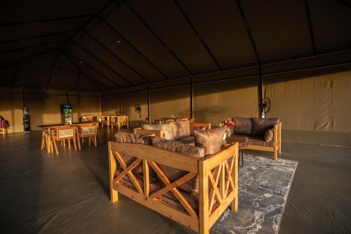 a room with couches and tables in a tent at Entalet Mara Camp in Talek