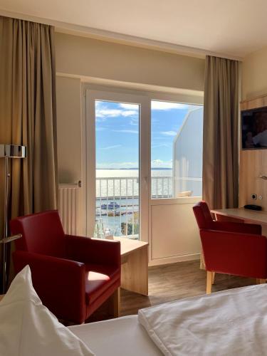 a hotel room with a bed and a window with a view at RÜGEN-HOTEL mit Ostseeblick in Sassnitz